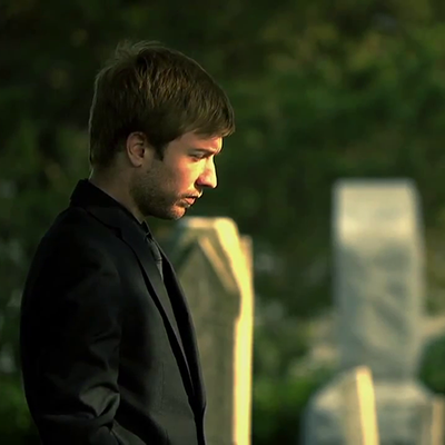 A still from a student film: a young man in a dark suit outdoors.
